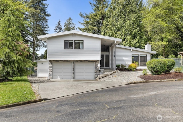 23255 133rd Ave SE, Kent, WA 98042 - split level home featuring an attached garage, a chimney, driveway, and stone siding