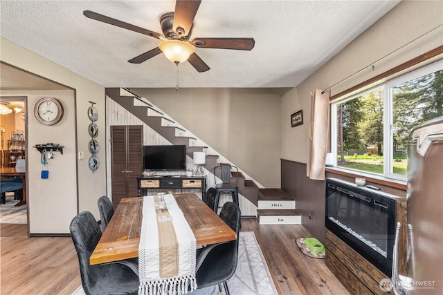 dining area with stairs, a textured ceiling, and wood finished floors