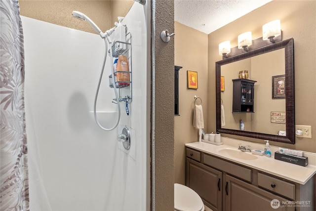 full bathroom with a textured ceiling, a shower with shower curtain, and vanity