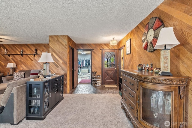 interior space with a textured ceiling and wood walls