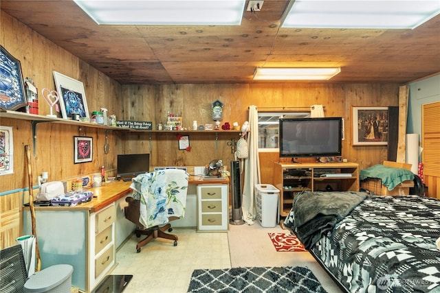 bedroom with wooden walls, tile patterned floors, and built in study area