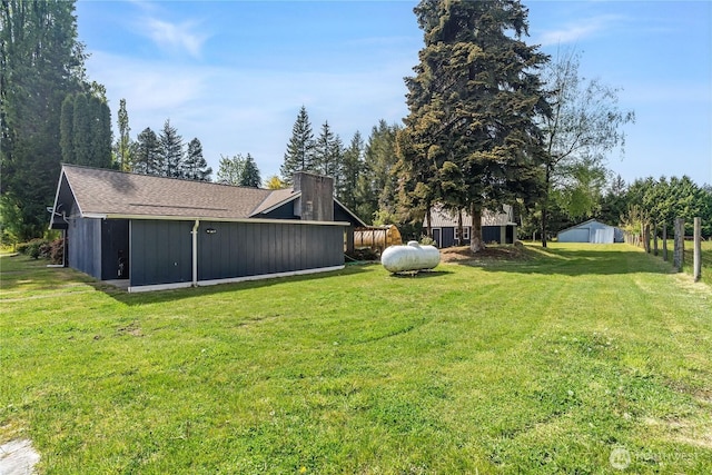view of yard with fence and an outbuilding