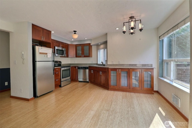 kitchen with plenty of natural light, stainless steel appliances, light wood finished floors, and visible vents