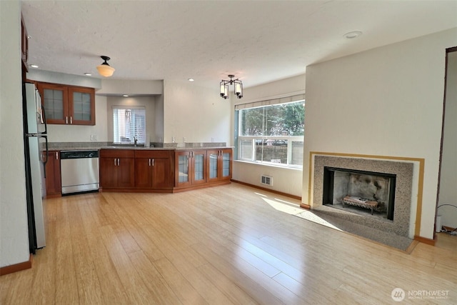 kitchen with appliances with stainless steel finishes, a wealth of natural light, light wood-style flooring, and visible vents