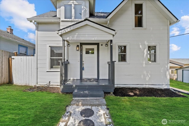 view of front of home with fence, a shingled roof, and a front lawn