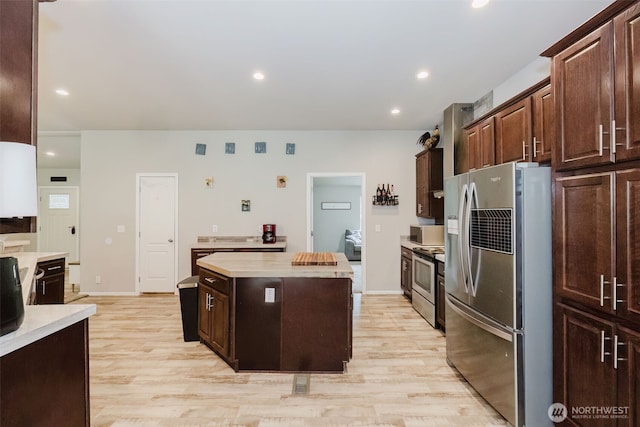 884 Cherub Pl E, Port Orchard, WA 98366 - kitchen with stainless steel appliances, a kitchen island, light wood-style flooring, dark brown cabinetry, and recessed lighting