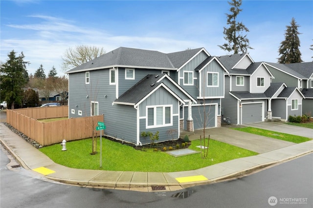 view of front of home with fence, roof with shingles, board and batten siding, an attached garage, and driveway
