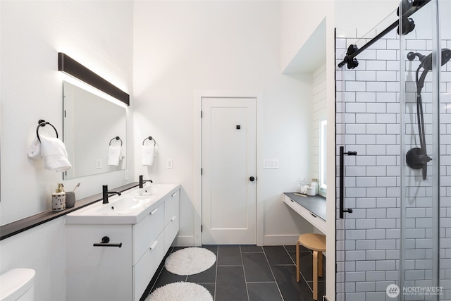 full bathroom with toilet, a tile shower, tile patterned flooring, and vanity