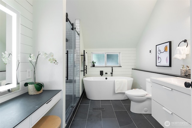 full bath featuring a freestanding tub, vaulted ceiling, a shower stall, vanity, and tile patterned floors
