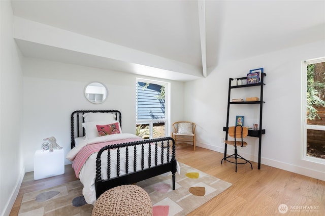 bedroom with vaulted ceiling with beams, baseboards, and wood finished floors