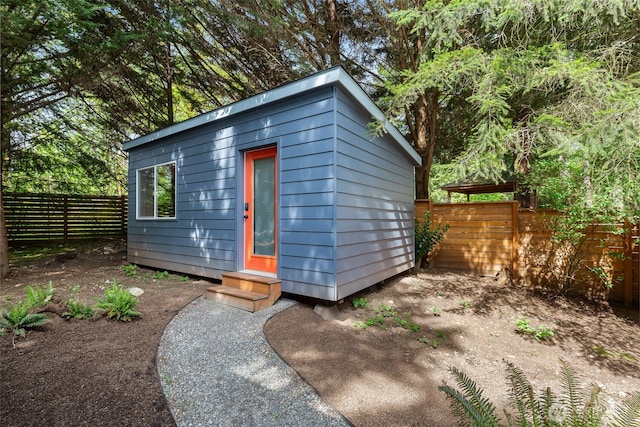 view of outbuilding with fence and an outbuilding