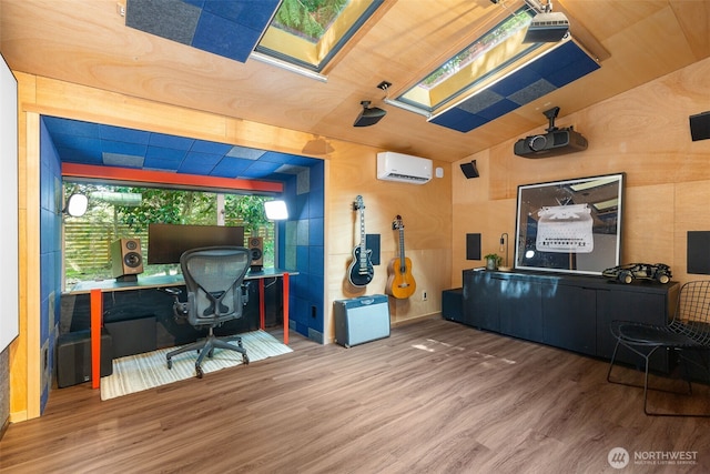 office area featuring an AC wall unit, a skylight, and wood finished floors