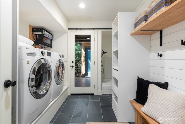 laundry area featuring washing machine and clothes dryer, dark tile patterned flooring, and laundry area