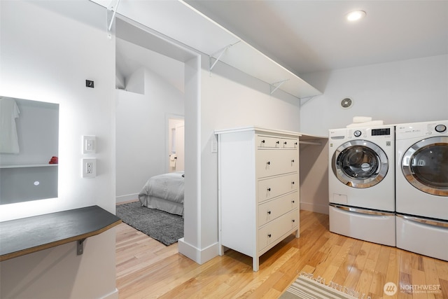 washroom featuring light wood-style floors, laundry area, baseboards, and independent washer and dryer
