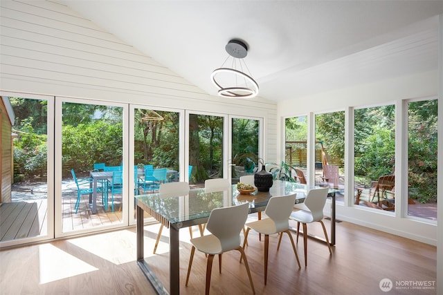 sunroom featuring vaulted ceiling and wood finished floors