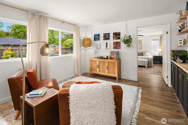sitting room with baseboards and wood finished floors