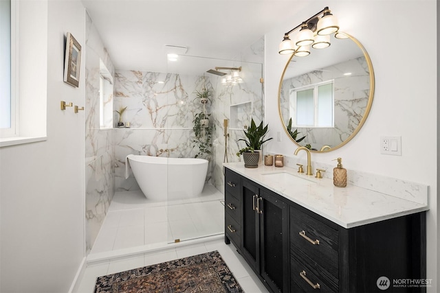 bathroom with a freestanding bath, vanity, and tile walls