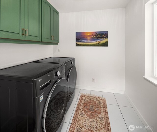 laundry area featuring tile patterned floors, baseboards, cabinet space, and washer and clothes dryer
