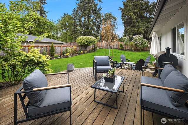 deck featuring a lawn, an outdoor living space, and a fenced backyard