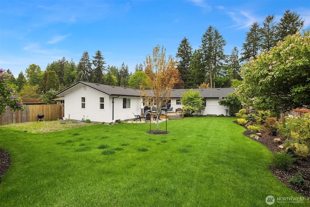 rear view of house with fence and a yard