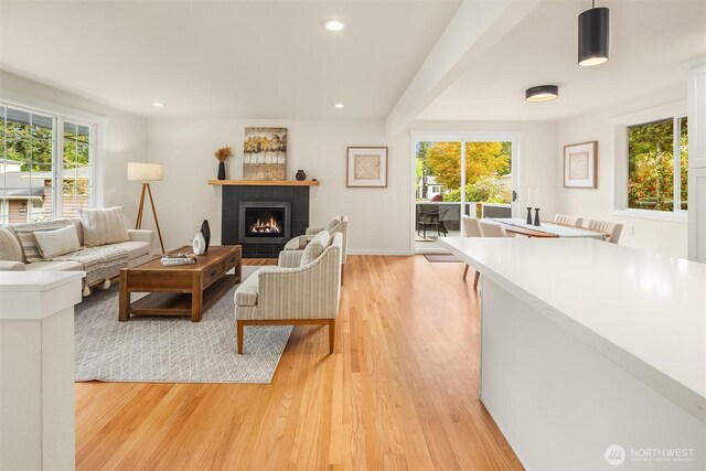 living area with plenty of natural light, recessed lighting, light wood-style flooring, and a tiled fireplace