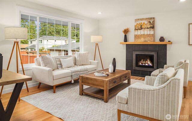 living room with recessed lighting, baseboards, wood finished floors, and a tile fireplace