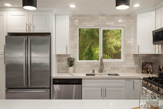 kitchen with light countertops, white cabinets, stainless steel appliances, and a sink