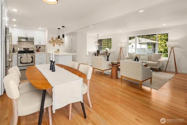 dining area featuring recessed lighting, baseboards, and light wood-type flooring