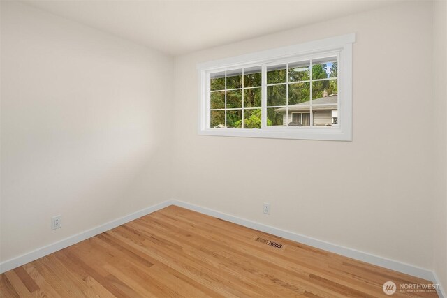 unfurnished room with baseboards, visible vents, and light wood-type flooring