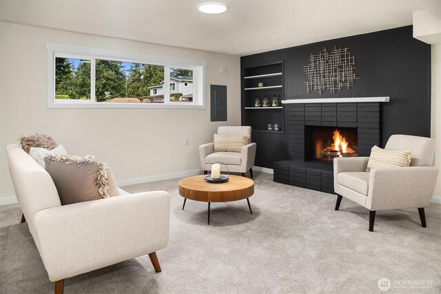 living area featuring a brick fireplace, baseboards, electric panel, built in shelves, and carpet flooring