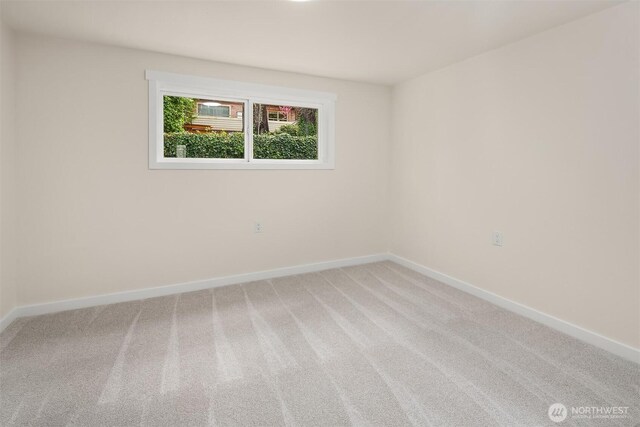 spare room featuring carpet floors and baseboards