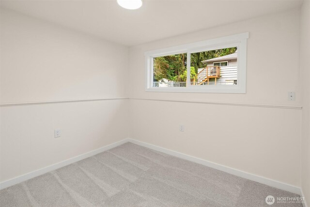 unfurnished room featuring carpet floors and baseboards