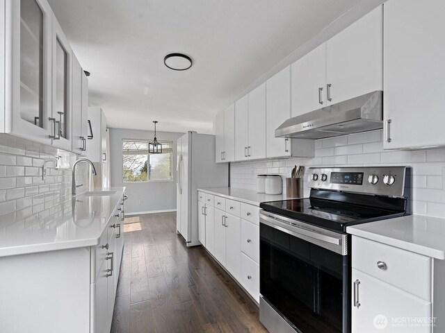 kitchen featuring light countertops, stainless steel electric range oven, under cabinet range hood, and dark wood-style floors