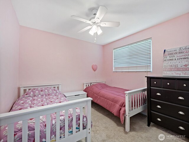 bedroom with a ceiling fan and light colored carpet