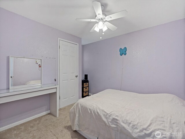 bedroom featuring baseboards, ceiling fan, and light carpet