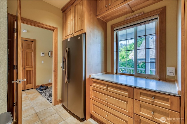 135 NE Boad Haven Rd, Belfair, WA 98528 - kitchen featuring refrigerator with ice dispenser, light countertops, light tile patterned floors, and brown cabinetry