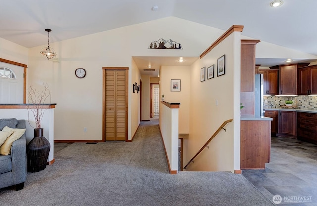 interior space with an upstairs landing, carpet floors, baseboards, lofted ceiling, and recessed lighting