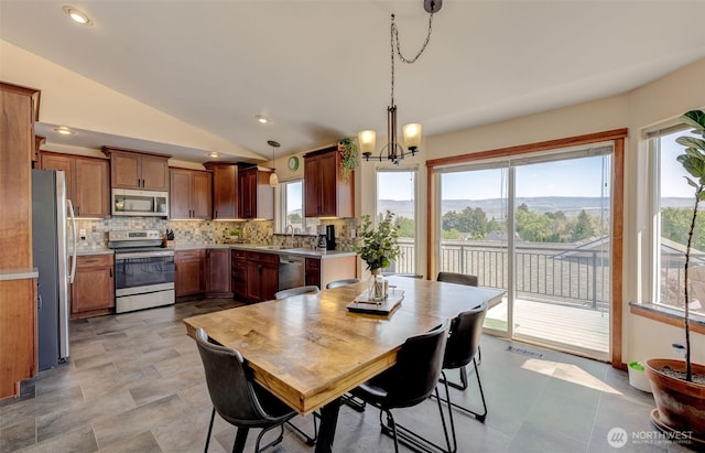dining space featuring vaulted ceiling, an inviting chandelier, and plenty of natural light