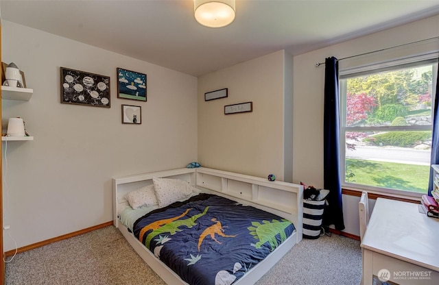 carpeted bedroom featuring multiple windows and baseboards