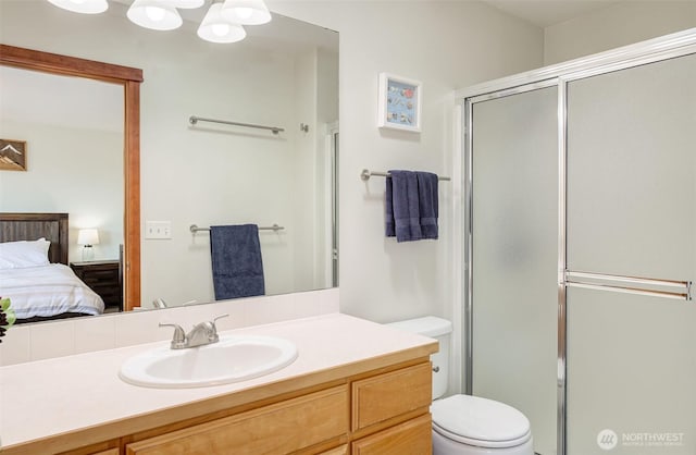 bathroom with connected bathroom, toilet, vanity, and an enclosed shower