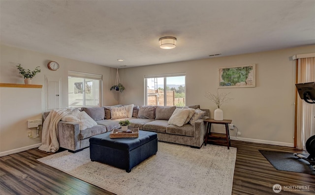 living room with baseboards, visible vents, and wood finished floors