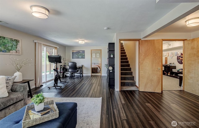 living room with dark wood-type flooring, baseboards, visible vents, and stairs