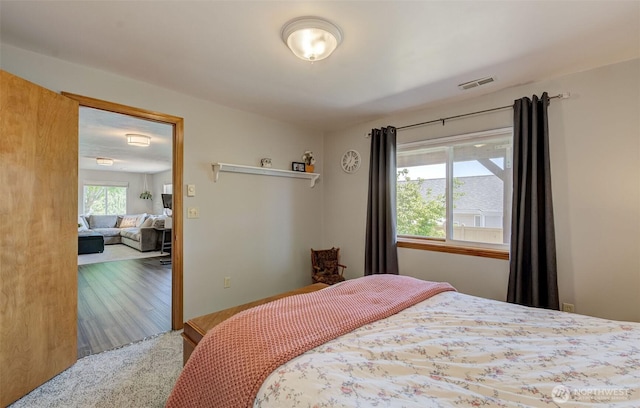 bedroom with visible vents and wood finished floors