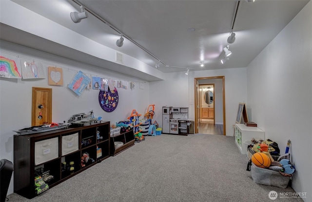 game room with rail lighting, visible vents, and carpet