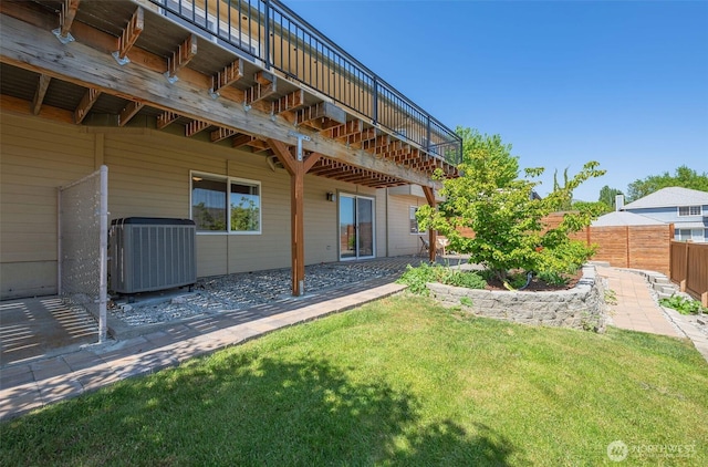 back of house featuring central air condition unit, a patio area, fence, and a lawn