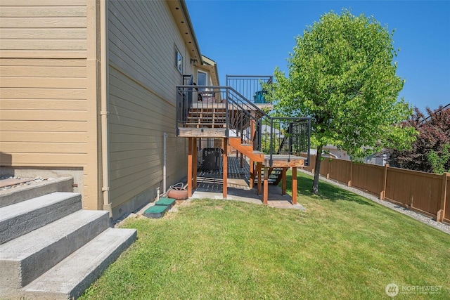 view of yard with stairway, a deck, and a fenced backyard