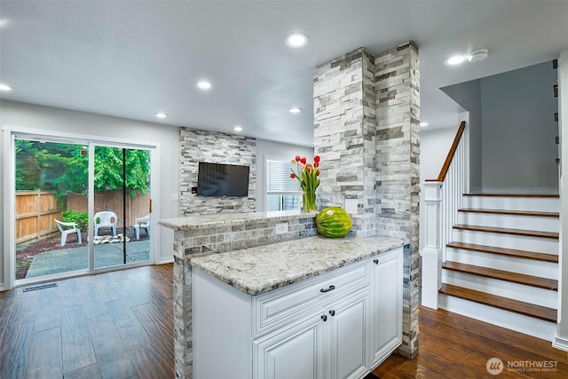 kitchen featuring dark wood finished floors, plenty of natural light, light stone countertops, recessed lighting, and white cabinets