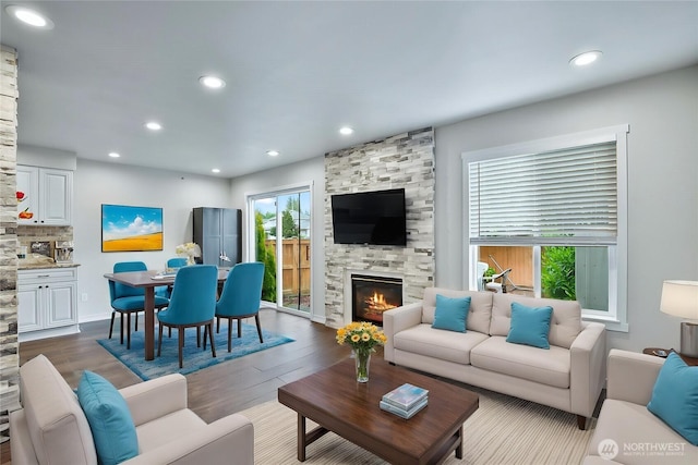 living room with dark wood finished floors, recessed lighting, and a large fireplace