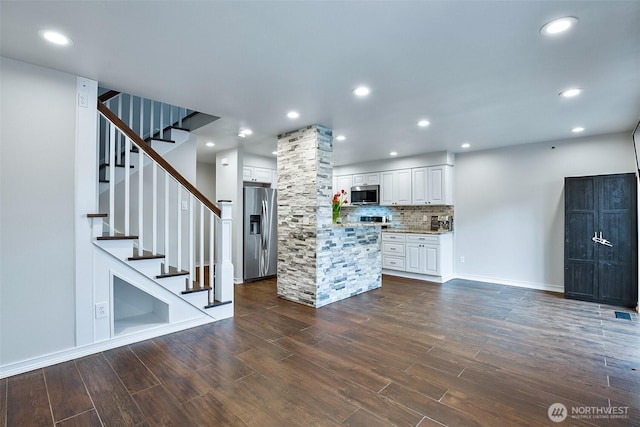 kitchen featuring appliances with stainless steel finishes, white cabinetry, dark wood-type flooring, a center island, and recessed lighting