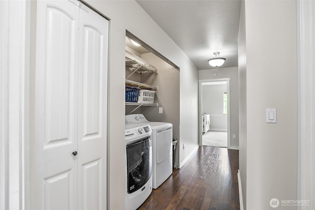 laundry room with washing machine and dryer, dark wood-type flooring, and baseboards